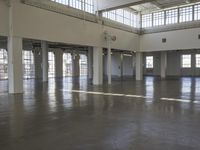 an empty empty warehouse with no roof, lots of windows and light coming in from high ceilings