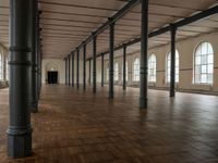 an empty warehouse like structure with wooden floors and arches in the middle of the room