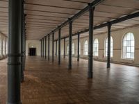 an empty warehouse like structure with wooden floors and arches in the middle of the room