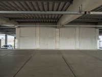 an empty industrial warehouse floor is shown from the inside outlining an overhead parking garage