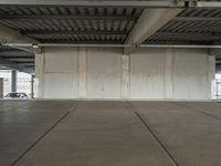 an empty industrial warehouse floor is shown from the inside outlining an overhead parking garage