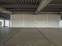 an empty industrial warehouse floor is shown from the inside outlining an overhead parking garage