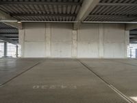 an empty industrial warehouse floor is shown from the inside outlining an overhead parking garage