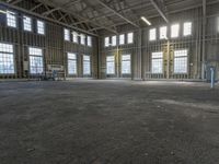 the empty warehouse has steel framing on all three floors and flooring it's gray