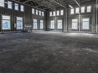 the empty warehouse has steel framing on all three floors and flooring it's gray