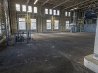 the empty warehouse has steel framing on all three floors and flooring it's gray