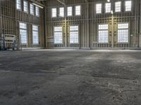 the empty warehouse has steel framing on all three floors and flooring it's gray