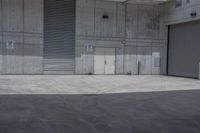 the empty warehouse area has a sliding door in it's middle and two empty doors that make a large room