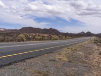 the yellow lines of a road running along side the mountain range are visible in this picture