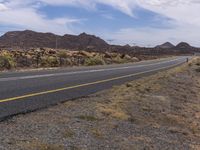 the yellow lines of a road running along side the mountain range are visible in this picture