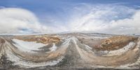 the reflection in a fisheye lens shows the scene in this photo of a large snow covered field