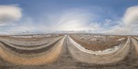 a panorama photograph of a field that has no vegetation in it and rocks around the field