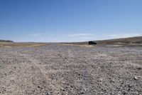 a truck that is parked on a dirt road in a barren landscape with tall grass