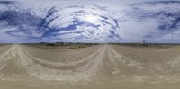 a panoramic view of the road in the desert of an open plain under a cloudy sky