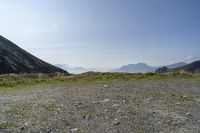 a motorcycle parked on a small mountain side road near mountains with no cars driving on it