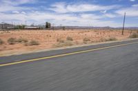 the road is quiet on a sunny day in the desert, with mountains in the distance