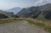 a motorcycle parked on a small mountain side road near mountains with no cars driving on it