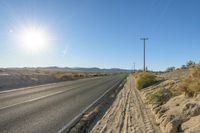 a lone road sits at the edge of the desert with a clear sky in the background