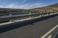 a freeway in the middle of a mountainous area with a train running along it and trucks and buses on the road behind