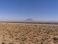 the view of a small sandy area in the middle of the desert with mountain in the distance