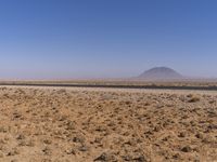 the view of a small sandy area in the middle of the desert with mountain in the distance