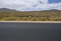 a motorcycle with no wheels is speeding along a deserted country road in the desert mountains