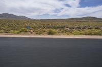 a motorcycle with no wheels is speeding along a deserted country road in the desert mountains