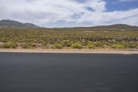 a motorcycle with no wheels is speeding along a deserted country road in the desert mountains