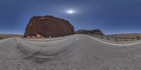 a desert landscape is shown through the 3d glasses of a man on a motorcycle riding along an empty paved road