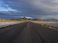 Endless Road Through Utah Desert with Dramatic Mountains