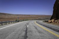 a long empty road with two lanes on both sides and a mountain in the distance