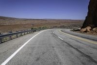 a long empty road with two lanes on both sides and a mountain in the distance