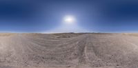 a desert is in the background with a bright sun shining over it, from a fish - eye lens