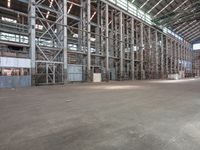 the inside of an industrial facility with metal support poles and floors and ceilings with high ceilings