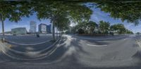 a fish eye lens showing a city with tall buildings in the background and trees in the foreground