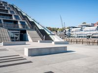 a building with stairs going down to a walkway next to a river thames waterway in a city