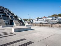 a building with stairs going down to a walkway next to a river thames waterway in a city