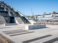 a building with stairs going down to a walkway next to a river thames waterway in a city