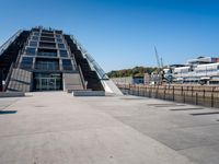 a building with stairs going down to a walkway next to a river thames waterway in a city