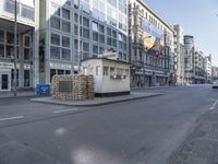 this small booth is next to a street and several buildings are on either side the intersection