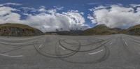 the view of the mountain range with the road painted black in the form of circles