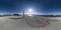 an image of a fish eye view of the water in a bay with graffiti on the sand