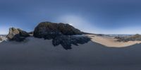 an image of a big beach view of a rock formation on top of the sand