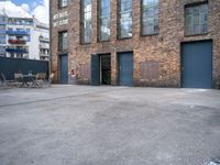 a street view of an alley with an outdoor table and chairs in front of a building