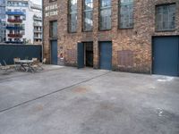 a street view of an alley with an outdoor table and chairs in front of a building