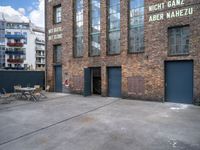 a street view of an alley with an outdoor table and chairs in front of a building