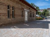 a brick building with an umbrella in the middle of it's courtyard area on a sunny day