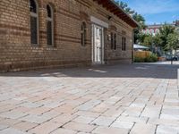 a brick building with an umbrella in the middle of it's courtyard area on a sunny day