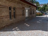 a brick building with an umbrella in the middle of it's courtyard area on a sunny day