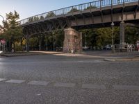 a view of the street and road beneath the bridge and the street light on top